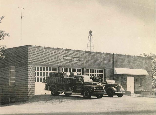 1951 - 1951 Ford/American LaFrance (newly delivered, note no red roof light yet) and 1939 Chevrolet Engine sit out front of 1949 Firehouse